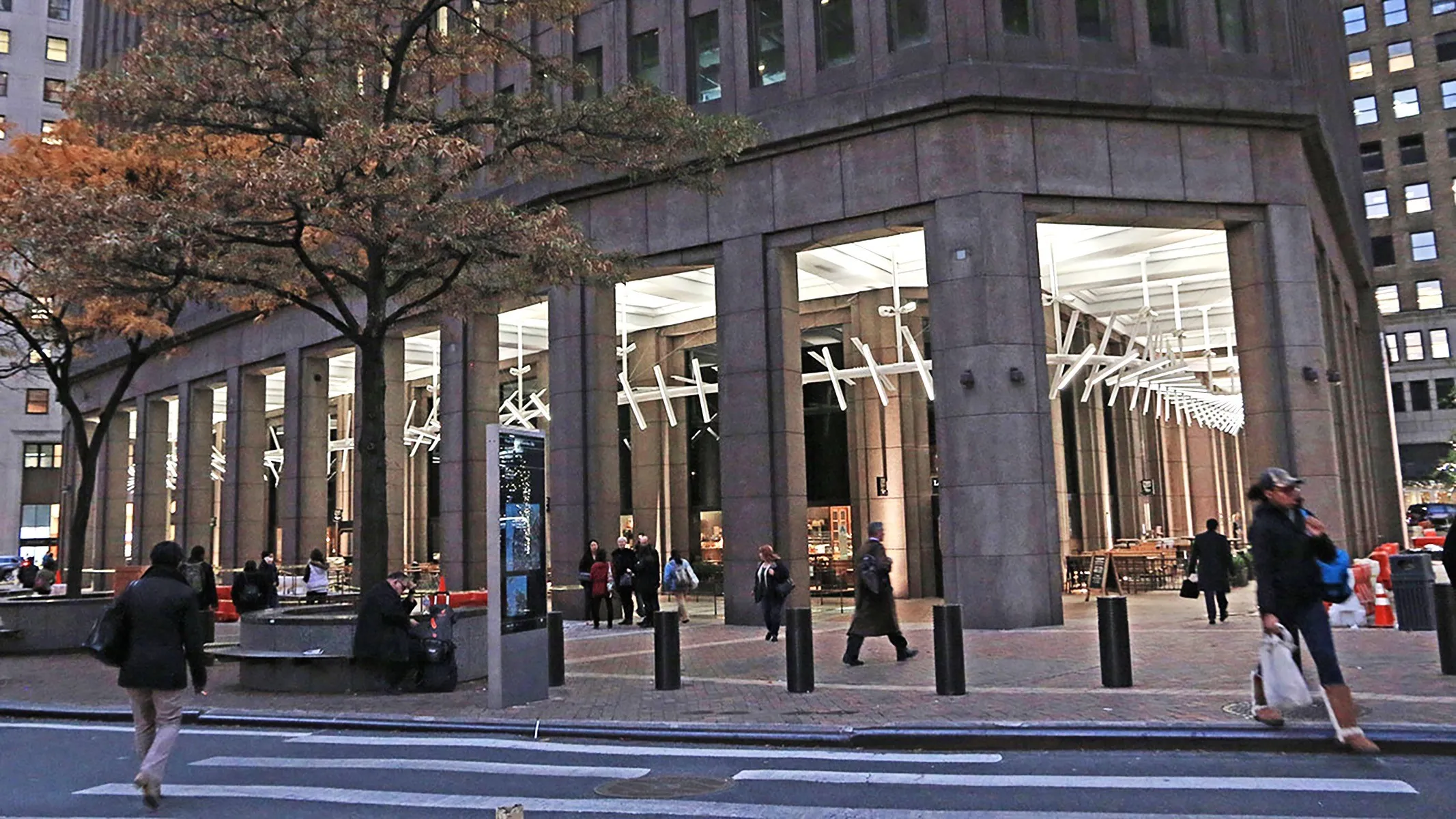 The exterior sculpture: a ribbon of white light bars and reflective blades winding through the arcade, seen from the street